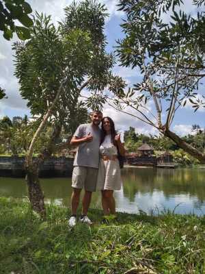 Couple by lake, thumbs up